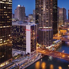 Aerial of buildings, river, and bridges at dusk